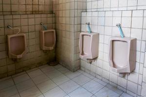 schmutzig alt Badezimmer, Interieur Öffentlichkeit Toilette Urinale im Männer Toilette Schüssel ist nicht sehr sauber. foto