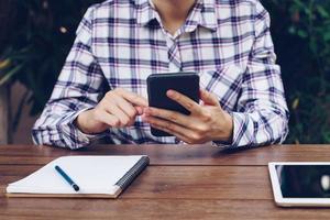 schließen oben Hand weiblich halten Telefon und Arbeiten im Cafe Restaurant. foto