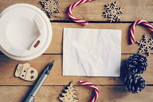oben Aussicht Kaffee Tasse und Stift, leer Papier auf Holz mit Weihnachten Dekoration zum Neu Jahr Konzept. foto