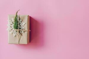 braun Geschenk Box auf das Rosa Hintergrund. minimal gestylt Urlaub Karte mit Kopieren Raum. foto