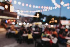 verschwommen Hintergrund beim Nacht Markt Festival Menschen Gehen auf Straße. foto