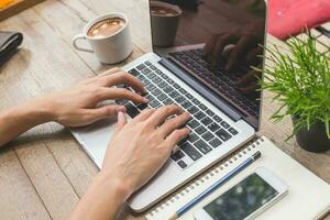 Mann Hände Tippen Laptop Computer im Kaffee Geschäft. foto