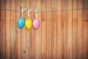 bunt Ostern Eier hängend auf hölzern Hintergrund, Jahrgang getönt. foto