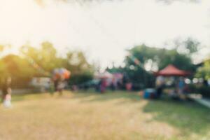 abstrakt verwischen Menschen und Sonnenlicht beim Festival im das Stadt Park Garten mit Bokeh Hintergrund. foto