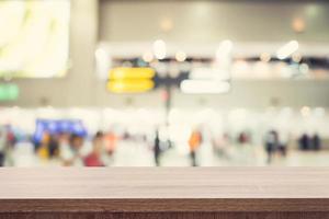 leeren hölzern Tabelle zum Produkt Platzierung oder Montage und verschwommen Terminal Abteilung beim Flughafen Hintergrund. foto