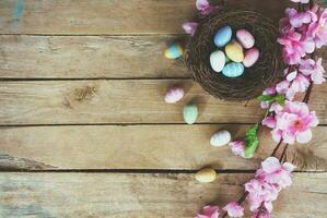 Kirsche blühen künstlich Blumen und Ostern Ei im Nest auf Jahrgang hölzern Hintergrund mit Kopieren Raum. foto