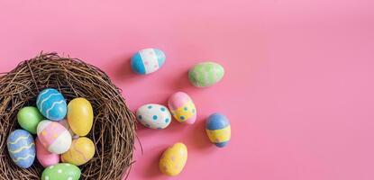 bunt Ostern Ei und Nest auf Rosa Pastell- Farbe Hintergrund mit Raum. foto