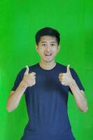 ausdrucksvoll beiläufig balinesisch asiatisch Kerl Modell- zum Werbung mit Grün Bildschirm Studio Hintergrund foto