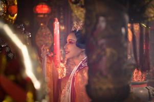 Chinesisch Frau machen wünscht sich, beten, und Licht Kerzen. auf das Gelegenheit von das jährlich Chinesisch Neu Jahr Festival, im ein verehrt Schrein oder Tempel foto