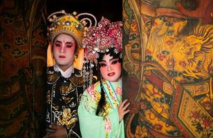 Porträt von männlich und weiblich Oper Darsteller beim das Eingang zu ein heilig Schrein oder Tempel, beten zum Segen auf das Gelegenheit von das jährlich Chinesisch Neu Jahr. foto