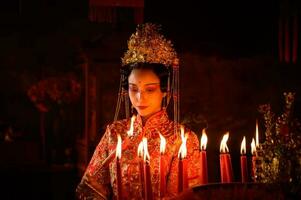 Chinesisch Frau machen wünscht sich, beten, und Licht Kerzen. auf das Gelegenheit von das jährlich Chinesisch Neu Jahr Festival, im ein verehrt Schrein oder Tempel foto