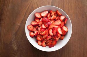 High Angle View von geschnittenen Erdbeeren in einer weißen Schüssel foto