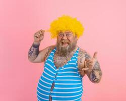 glücklich Mann mit Gelb Perücke und Badeanzug ist bereit zu das Sommer- foto