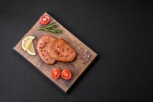 zwei gebacken Scheiben von Thunfisch Filet mit Gewürze und Kräuter foto