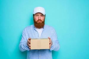 Kurier mit Hut ist unzufrieden zu liefern ein Karton Box foto