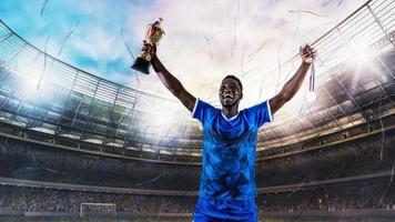 Fußball Spieler im Blau Uniform freut sich zum das Sieg von ein Trophäe beim das Stadion foto