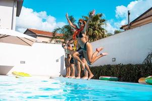 Gruppe von freunde im Badeanzug genießen im ein Schwimmen Schwimmbad foto