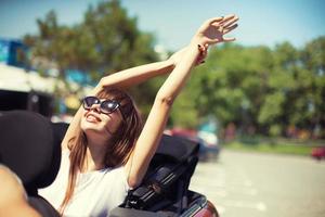 jung Frau im Cabriolet Auto fährt ab zum das Sommer- Ferien foto