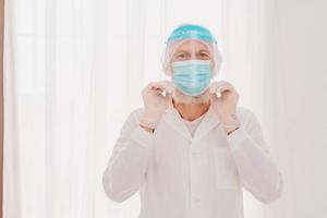 Arzt mit Maske und Gesicht Schutz ist bereit zu Arbeit im Krankenhaus foto