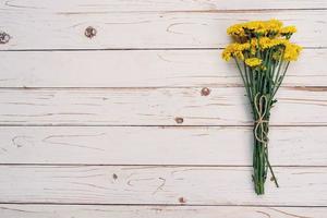 Gelb Blumen von Strauß, oben Aussicht auf Weiß hölzern Hintergrund Textur mit Kopieren Raum foto