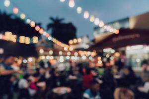 verschwommen Hintergrund beim Nacht Markt Festival Menschen Gehen auf Straße. foto