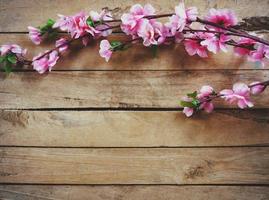 Kirsche blühen und künstlich Blumen auf Jahrgang hölzern Hintergrund mit Kopieren Raum. foto