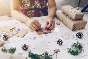 Frau Hand Herstellung schön Weihnachten Karte beim Tabelle foto