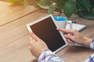 asiatische Frau mit Tablette auf Tisch im Café foto