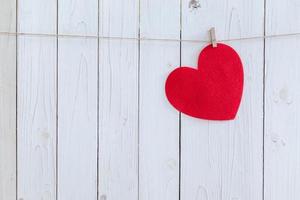 rot Herz hängend auf Weiß Holz Hintergrund mit Kopieren Raum. foto