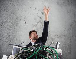 Geschäftsmann gefangen durch Kabel. Konzept von Stress und Überarbeitung foto