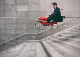 leichtsinnig Geschäft Mann geht Nieder das Treppe mit ein Auto zu erhalten Vor das Andere. Konzept von Erfolg und Wettbewerb foto