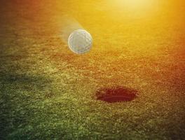 Golf Ball in der Nähe von das Loch im ein Gras Feld foto