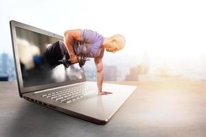 persönlich Trainer tut Fitnessstudio Lektion durch Internet und Laptop foto