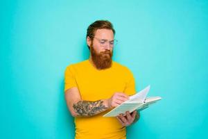 Mann mit Gelb T-Shirt liest ein Buch foto