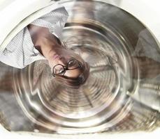 verwirrt Geschäftsfrau hat Schwindel Innerhalb ein Waschen Maschine. Konzept von Stress und Überarbeitung foto