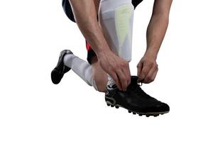 Fußball Spieler einstellen seine Schuhe Vor das passen. isoliert auf Weiß Hintergrund foto