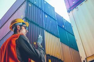 Arbeiter kommunizieren mit Radio zu Steuerung Wird geladen Behälter beim Hafen Ladung foto