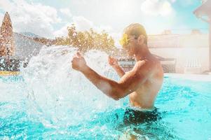 Mann im Badeanzug genießen im ein Schwimmen Schwimmbad foto