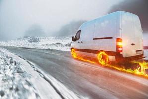 Weiß van mit feurig Räder auf ein Schnee bedeckt Straße foto