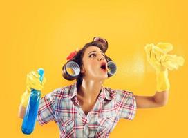 Mädchen Hausfrau mit Handschuhe und sprühen bereit zu sauber foto