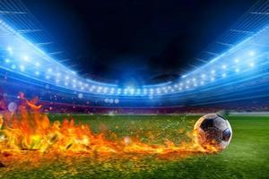 Fußball Ball im Flamme geht schnell zu das Stadion Feld foto