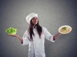 Koch unentschieden zwischen frisch Salat oder Pasta Gericht foto