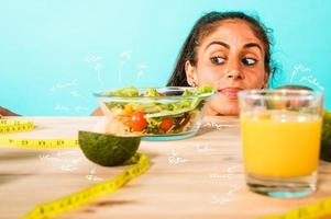 Frau bereitet vor ein gesund Mahlzeit mit Salat und Orange Saft foto