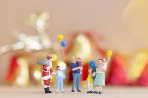 glückliche Miniaturfamilie, die Weihnachten, Weihnachten und ein frohes neues Jahrkonzept feiert foto