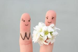 Finger Kunst von glücklich Paar. Mann ist geben Blumen zu Frau. foto