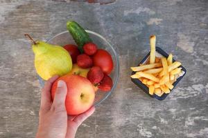 Französisch Fritten, Früchte, Gemüse auf alt hölzern Hintergrund. Konzept wählen richtig Ernährung oder von Müll Essen. oben Sicht. foto