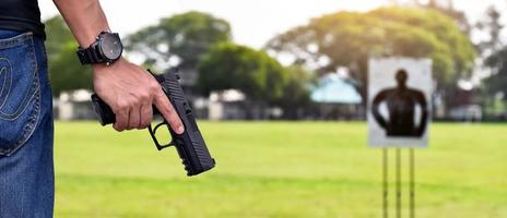 9-mm-Automatikpistole in der rechten Hand des Schützen, Konzept für Sicherheit, Raub, Gangster, Leibwächter auf der ganzen Welt. selektiver Fokus auf Pistole. foto