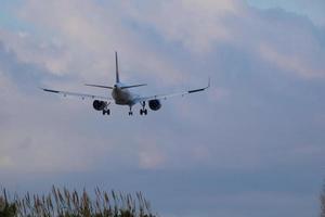 kommerziell Flugzeug überfliegen das Himmel und ankommen beim Flughafen foto