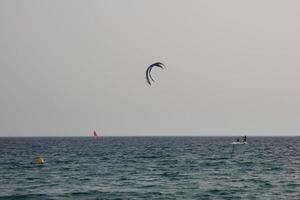 Windsurfen, Kitesurfen, Wasser- und Windsport mit Segeln oder Drachen foto