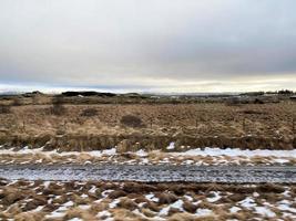 isländisch Winter Landschaft mit Schnee bedeckt Hügel und Blau wolkig Himmel foto